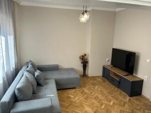 sala de estar con sofá y TV de pantalla plana en Niya Apartment Bourgas, en Burgas