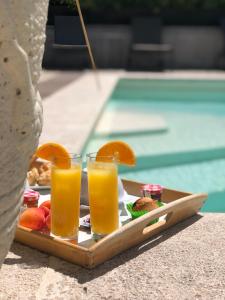 - un plateau de nourriture avec deux verres de jus d'orange dans l'établissement Hôtel Les Magnanarelles, à Maussane-les-Alpilles