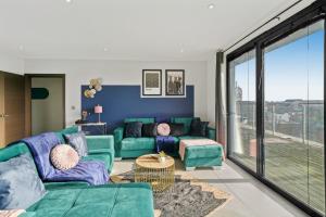 a living room with a green couch and a table at Stunning Penthouse in Chelmsford - Large Rooftop in Chelmsford