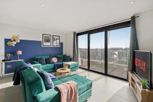 a living room with a couch and a tv at Stunning Penthouse in Chelmsford - Large Rooftop in Chelmsford