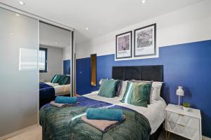 a bedroom with a large bed with blue walls at Stunning Penthouse in Chelmsford - Large Rooftop in Chelmsford