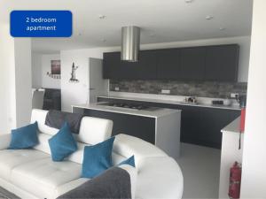 a living room with a white couch and blue pillows at Ocean View Apartments in Looe