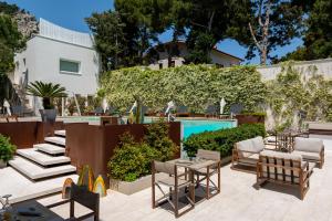 a patio with chairs and a swimming pool at Unìco Boutique Hotel d'Arte in Mondello