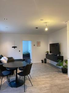 a living room with a table and chairs and a tv at Lovely 2 bedroom condo in Reykjavík