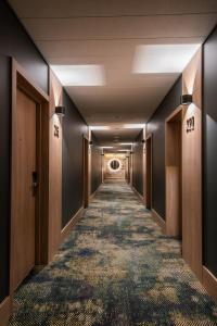 corridoio di un corridoio di un hotel con: di CONTI HOTEL VILNIUS, Conference Centre, Restaurant & Bar a Vilnius