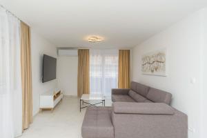 un soggiorno con divano e TV di Apartmani Šimi - The Sun a Crikvenica
