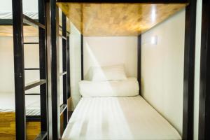 a small bed in a small room with a wooden ceiling at Starfish Alley Hostel in Danang