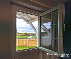 two windows in a room with a view of a fence at The Paddock in Killyleagh