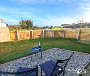 a patio with two chairs and a table with wine glasses at The Paddock in Killyleagh