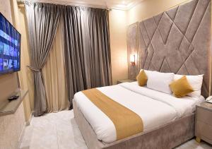 a hotel room with a large bed and a television at كريستال الخليج للشقق الفندقيه in Kuwait