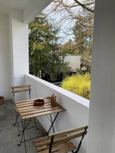 balcón con mesa, sillas y ventana en Gemütliche Wohnung Nähe Uni en Basilea