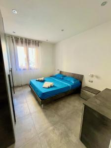 - une chambre avec un lit bleu dans l'établissement Becky's House casa vacanze, à Quartu SantʼElena