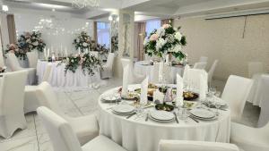 un comedor con mesas blancas y sillas blancas en Hotel Verhovina, en Kiev