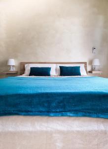 uma grande cama azul com duas almofadas azuis em The Hat em Olbia