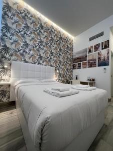 a white bedroom with a large white bed with a wall at CH TANEZ CAROLINA a in Madrid