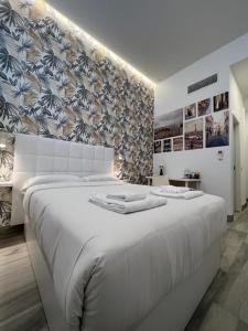 uma grande cama branca num quarto com uma parede em CH TANEZ CAROLINA a em Madri