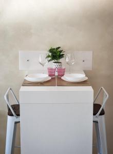 uma mesa com dois copos de vinho e uma planta em vasos em The Hat em Olbia
