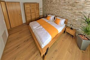 uma cama grande num quarto com uma parede de tijolos em Alb Fe Wo em Sankt Johann