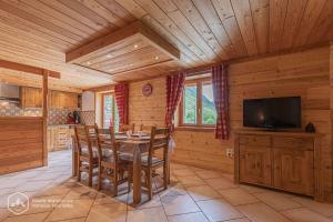 a dining room with a table and a television in a cabin at Le chalet d'Emile in Bonneval-sur-Arc