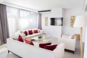 sala de estar con sofá blanco y almohadas rojas en No81 Hotel, en Golturkbuku