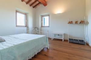 マチェラータにあるItalian Experience-Villa Lunaの白いベッドルーム(ベッド1台、窓2つ付)