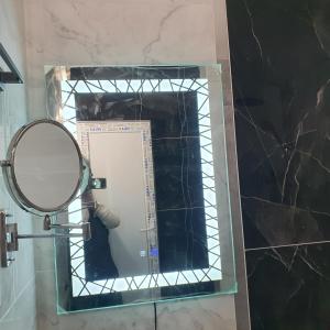 espejo en el baño con una persona que toma una foto en Capitan Niko Apartments en Burgas