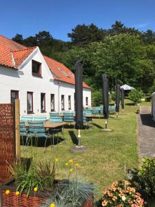 un groupe de chaises et de tables dans une cour dans l'établissement Ibsens Gaard, à Ebeltoft