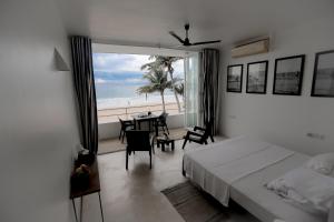 a bedroom with a bed and a view of the beach at Bieshu Beach Hive in Habaraduwa