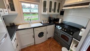a kitchen with a sink and a washing machine at Freedom House in Clacton-on-Sea