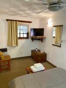 a room with a bed and a tv in it at Hotel Samay Huasi in Villa General Belgrano