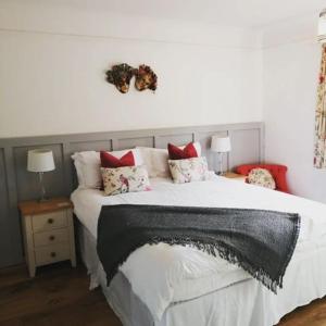 a bedroom with a large bed with red pillows at South View House in Waterlooville