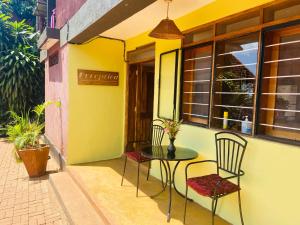 - une terrasse avec une table et des chaises dans un bâtiment dans l'établissement Home OnThe Nile Dorm, à Jinja