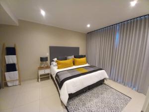 a bedroom with a large bed with yellow pillows at The Pier no. 7 in Swakopmund