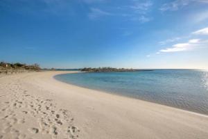 a beach with footprints in the sand and water at Casa Tairsia in Torre Lapillo