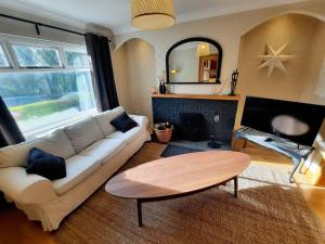 uma sala de estar com um sofá branco e uma mesa em - The Holly Tree House - em Bushmills