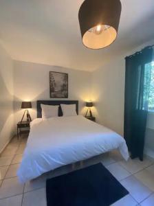 um quarto com uma grande cama branca e 2 candeeiros em Villa Arethuse - Pyla sur Mer em Pyla-sur-Mer