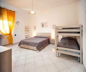 a bedroom with two beds and a bunk bed at Casa Tairsia in Torre Lapillo