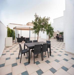 a patio with a table and chairs on a tiled floor at Casa Tairsia in Torre Lapillo
