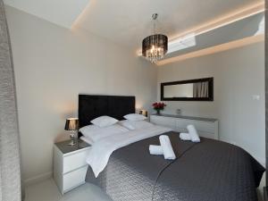 een witte slaapkamer met een groot bed met witte kussens bij atHome in Krakau