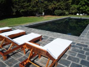 een zwembad met 2 ligstoelen ernaast bij Villa Victoria Lodge in Maipú