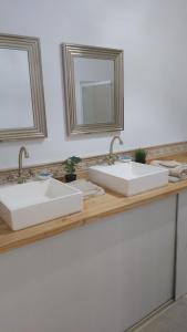a bathroom counter with two sinks and a mirror at Buhardilla en el Cantón in Ferrol