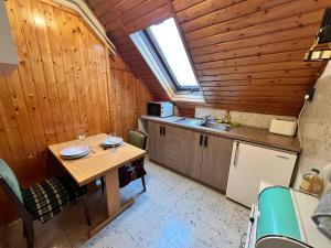 małą kuchnię ze stołem i oknem w obiekcie A Festő Vendégháza / The Painter's Guest House w mieście Zánka +14 zdjęć