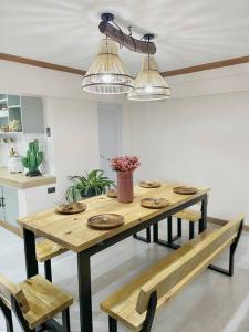 einen Holztisch und Bänke in einer Küche mit Beleuchtung in der Unterkunft Ba-lai homes in Baguio City