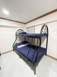 a bunk bed in a room with blue sheets at Ba-lai homes in Baguio