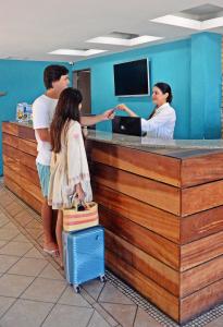 a group of people standing at a counter at Cais da Praia Hotel in Maceió