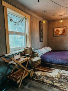 a bedroom with a bed and a desk and a chair at Private Farm Jakuzzi Sauna in the forest in Talsi