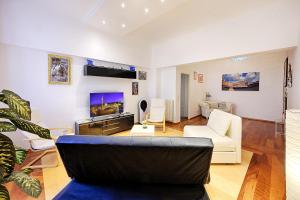 ein Wohnzimmer mit einem Sofa und einem TV in der Unterkunft Ele Home in Siena