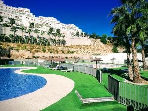 ein Resort mit einem Pool, Palmen und einem Gebäude in der Unterkunft Residencial Xeresa del Monte Solo Familias Serviplaya in Jeresa