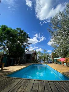 una piscina azul con terraza de madera en Huecubu suites en San Miguel del Monte