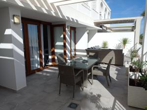 eine Terrasse mit einem Tisch und Stühlen darauf in der Unterkunft Residencial Xeresa del Monte Solo Familias Serviplaya in Jeresa